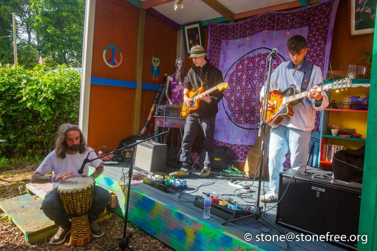 Live band performing on an outdoor ReKINDle Festival stage.