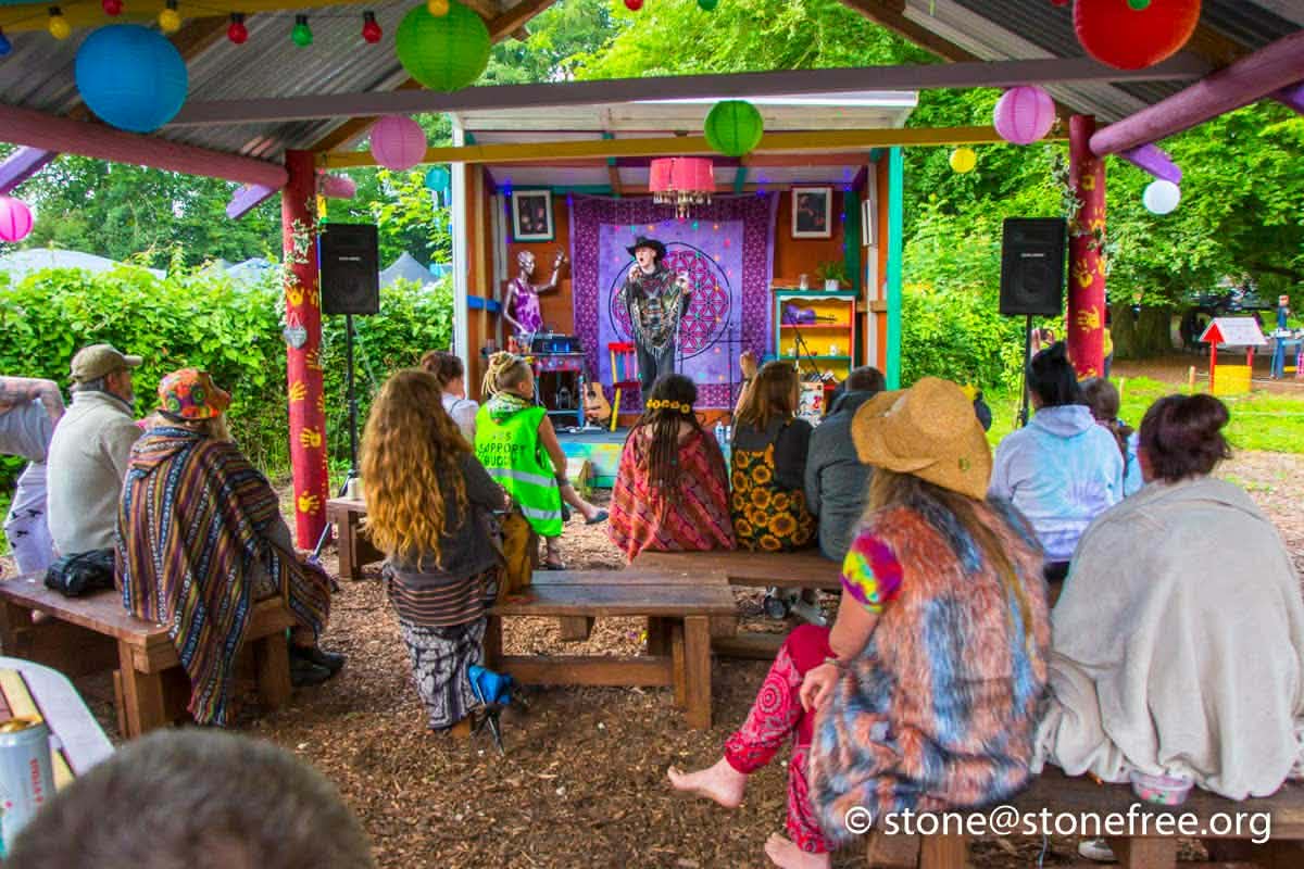 Colourful outdoor festival area with stalls and people.