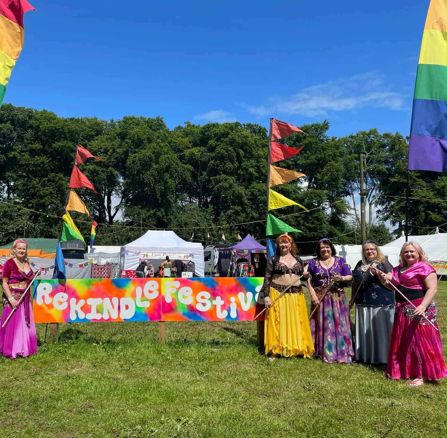 Colourful festival field with flags and open sky.
