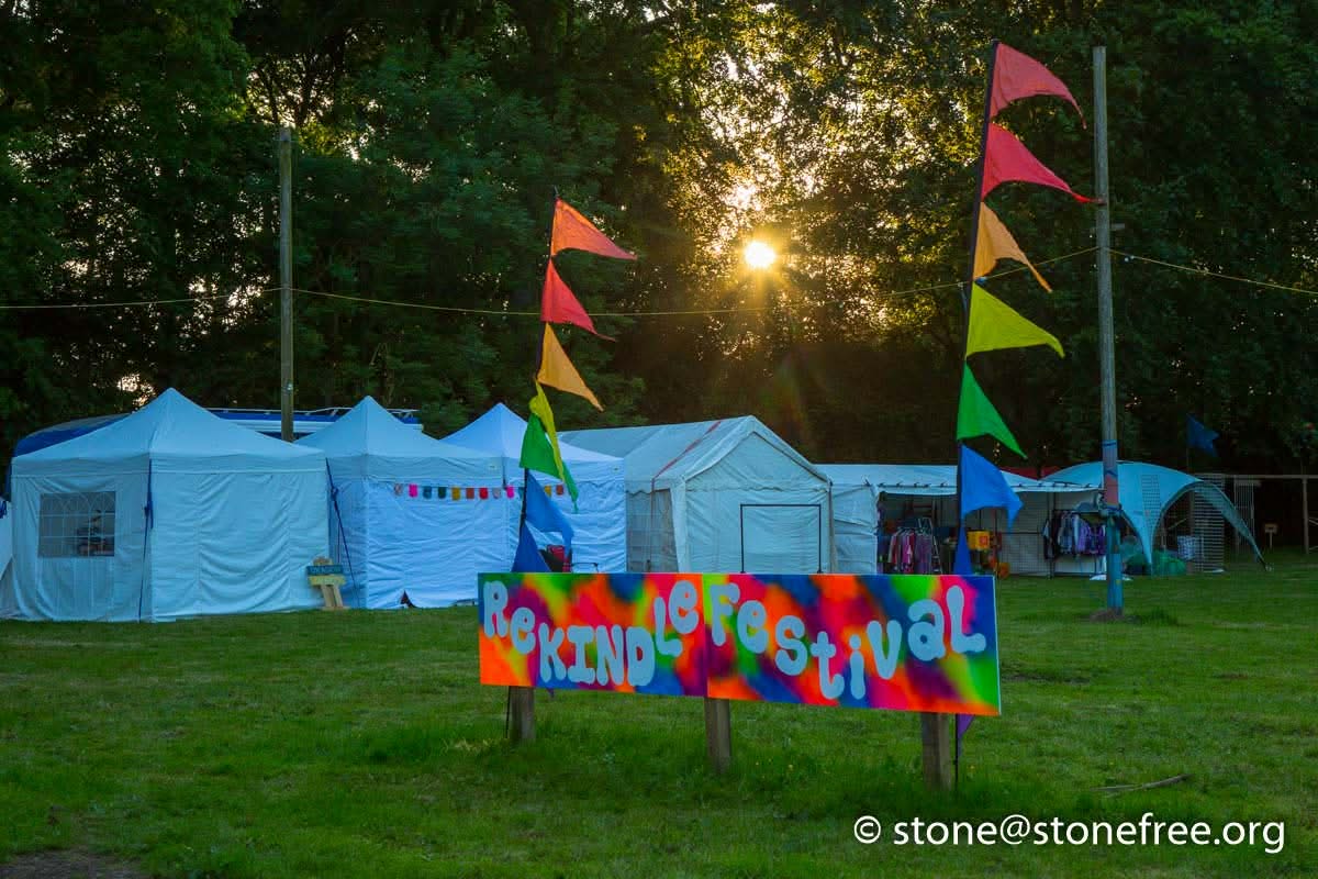 Festival camping area with tents and colourful flags.
