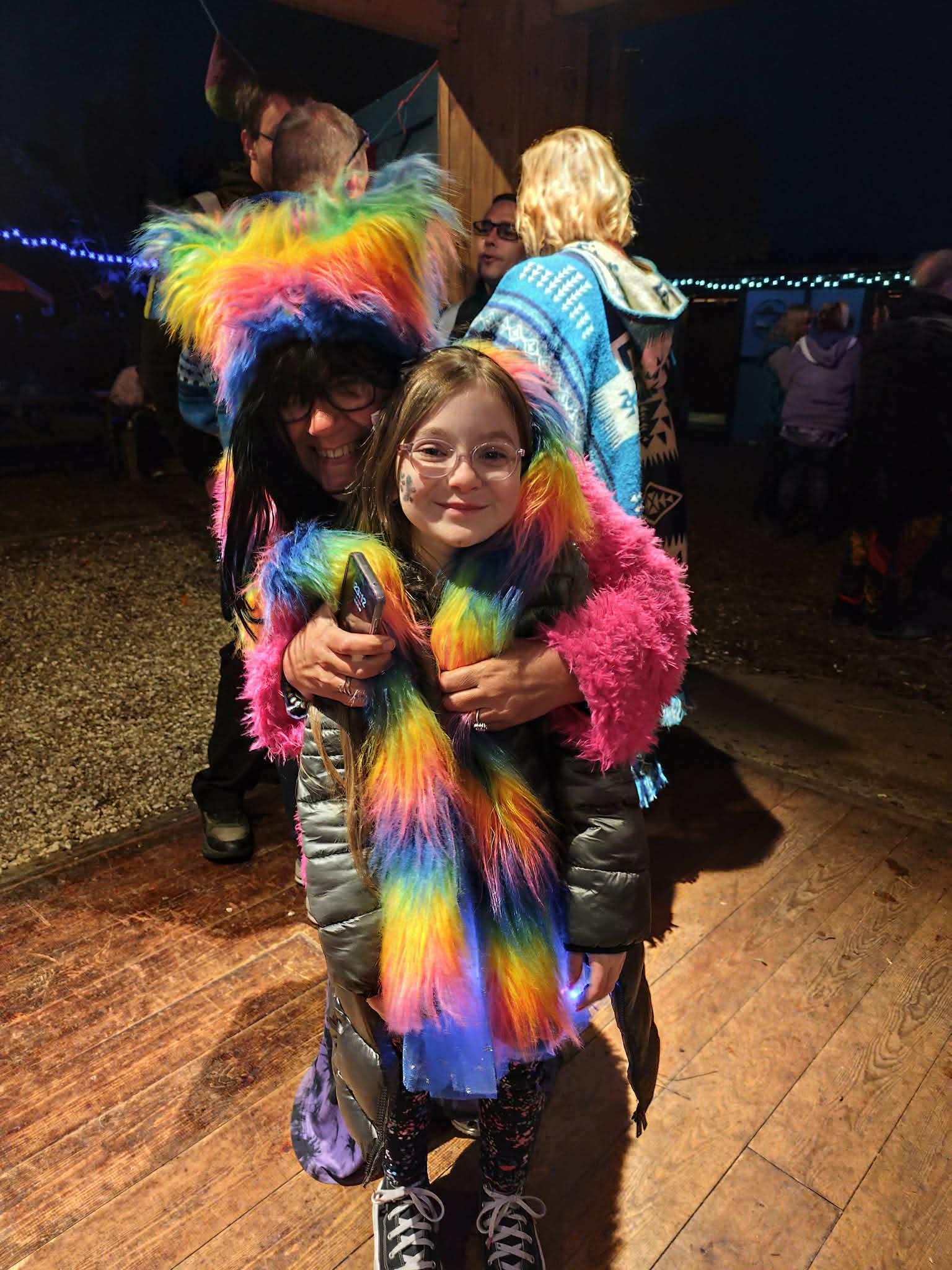Festival-goers wearing bright lights and colourful outfits.