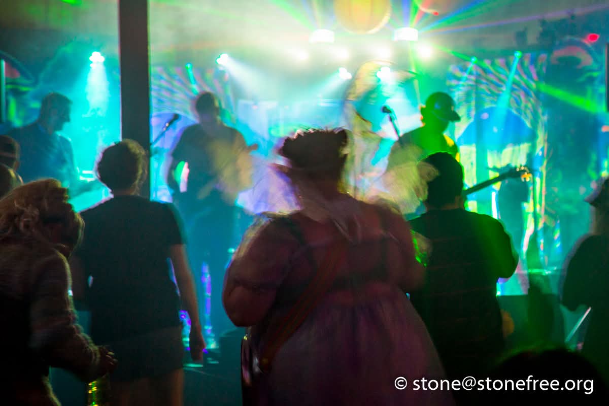 Dance tent with colourful lights and people dancing.
